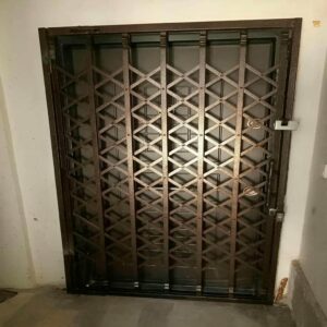 حفاظ درب آکاردئونی فلزی مشکی با اتصالات مقاوم برای ورودی ساختمان در یزد
