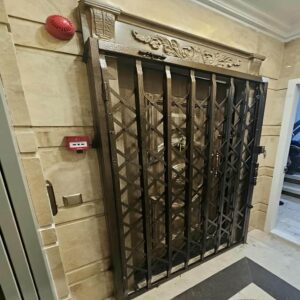 حفاظ درب آکاردئونی فلزی مشکی برای کنترل ورودی ساختمان در استان ایلام