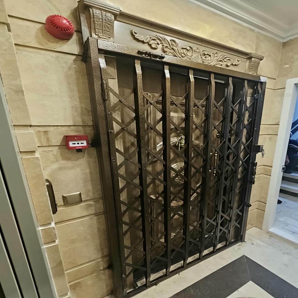 حفاظ درب آکاردئونی فلزی مشکی برای کنترل ورودی ساختمان در استان ایلام