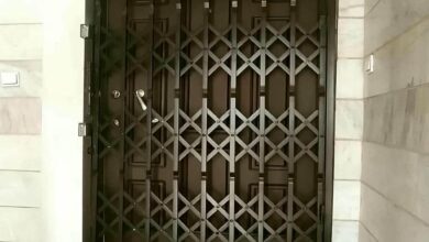 حفاظ درب آکاردئونی فلزی مشکی برای کنترل ورودی ساختمان در همدان