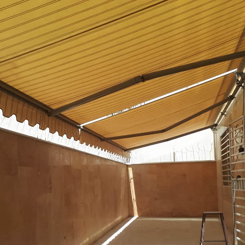 سایبان بازویی نصب شده روی بالکن ساختمان مسکونی