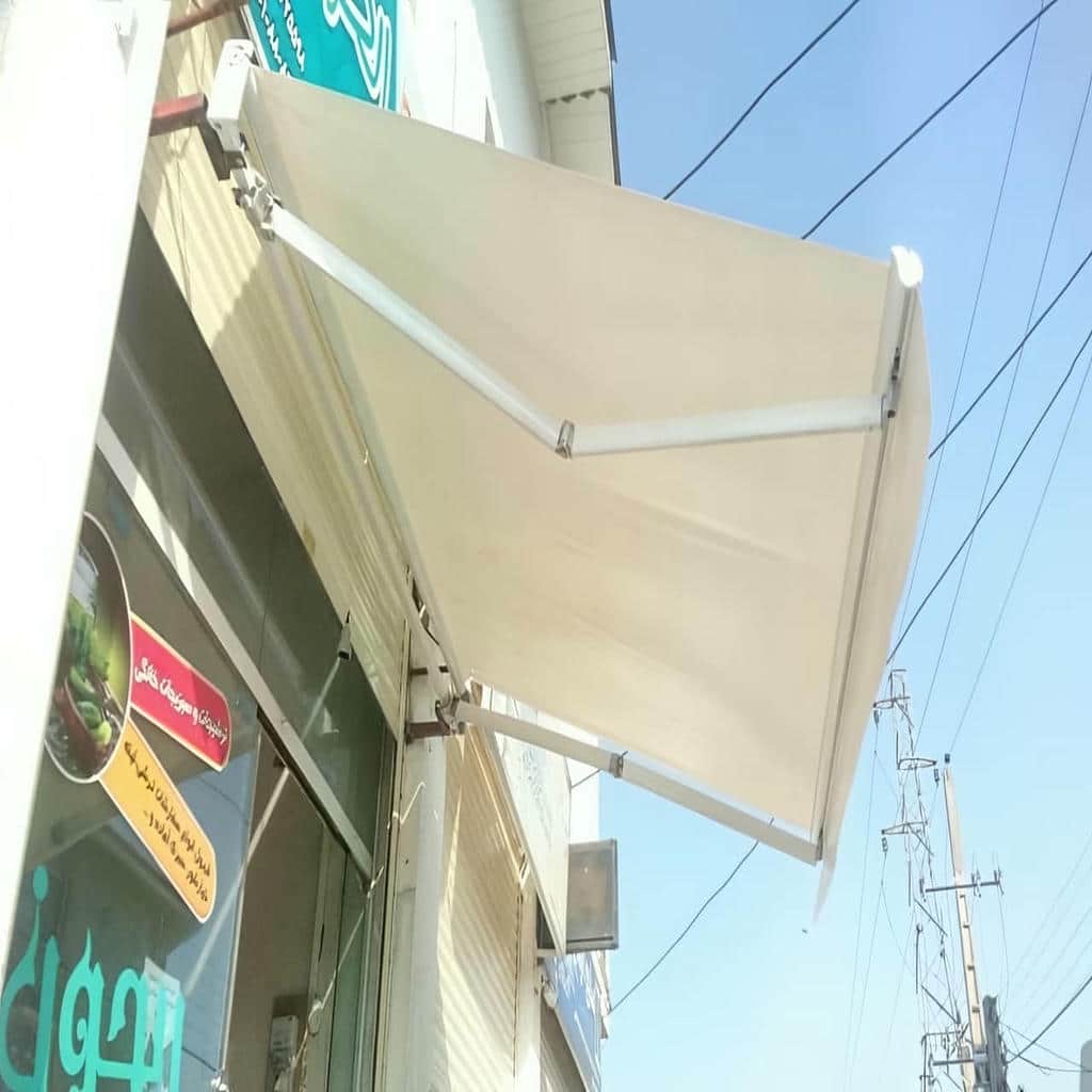 چادر برقی با سازه جمع شده کنار نمای ساختمان
