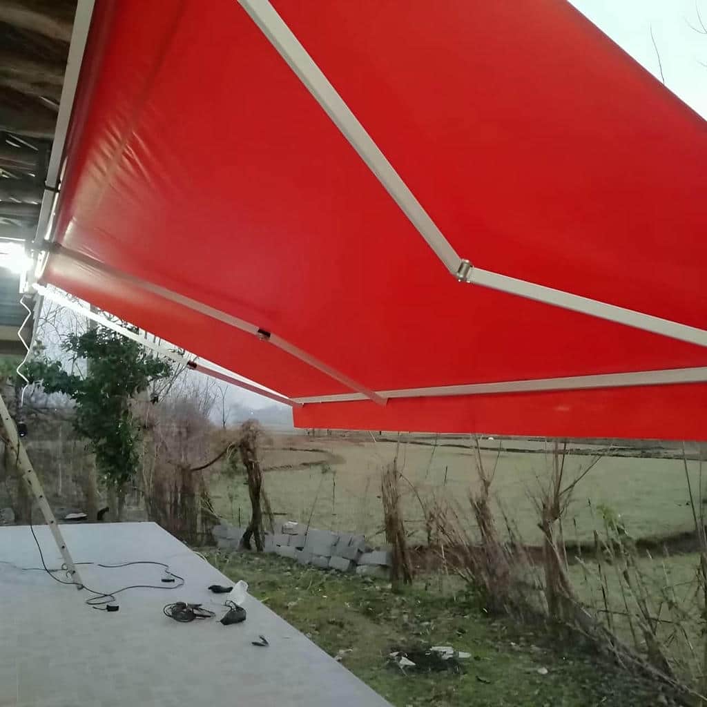 سایبان برقی با پارچه طوسی هماهنگ با نمای ساختمان در تهران