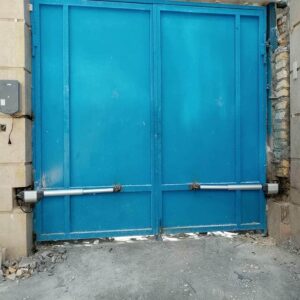 جک درب پارکینگ در ایلام با بازوی فلزی روی ورودی ساختمان قدیمی