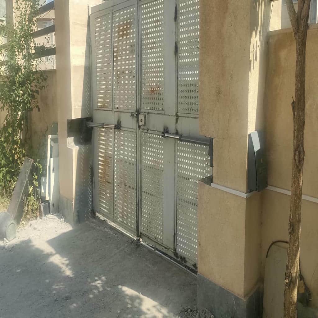 جک درب پارکینگ در استان فارس نصب شده روی درب فلزی دو لنگه